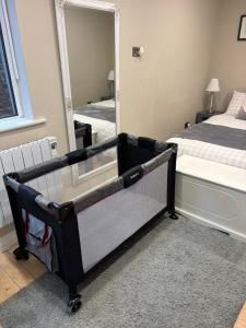 a bedroom with a crib in front of a mirror at Modern secure townhouse in Oldcastle