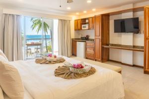 a room with a large white bed with a view of the ocean at Residencias Samara in Sámara