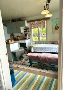 a bedroom with a bed and a kitchen at Summer cottage Taipalsaari in Vehkataipale