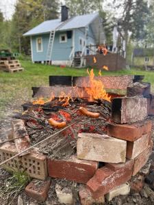 a brick fire pit with hot dogs on it at Summer cottage Taipalsaari in Vehkataipale