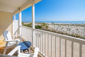 eine Veranda mit zwei Stühlen und Blick auf den Strand in der Unterkunft Drifting Sands Oceanfront Hotel in Ship Bottom