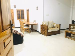 a living room with a table and a couch at Blue Deer Villa in Trincomalee