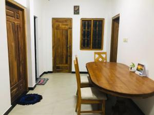 a dining room with a wooden table and chairs at Blue Deer Villa in Trincomalee +6 photos