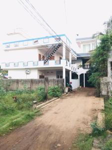 an empty dirt road in front of a white building at Blue Deer Villa in Trincomalee