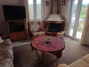 a living room with a table and a fireplace at Όμορφο φυσικό περιβάλλον in Filippiada