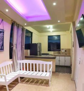 a room with two white benches and a kitchen at Hostal Peña de Carlo in Toluca