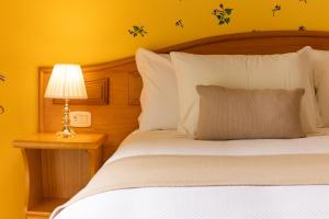 a bedroom with a bed and a lamp on a table at Hotel Pousada da Neve in Nova Petrópolis