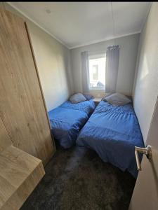 two beds in a small room with a window at Crozzer's Place in Heysham