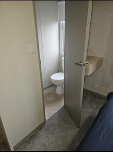 an open door to a bathroom with a toilet at Crozzer's Place in Heysham +7 photos