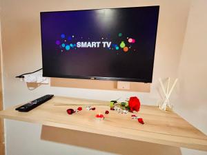 a television sitting on a table with a keyboard and flowers at Pula Zone Chalets in Maun