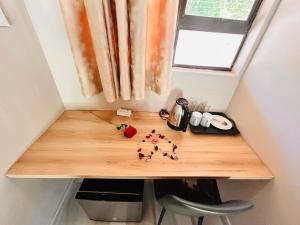 a wooden table in a tiny room with a window at Pula Zone Chalets in Maun