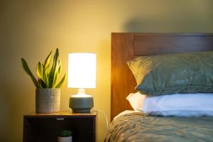 a lamp on a night stand next to a bed at Golf Links Cottage - Views of Royal County Down Golf Course in Newcastle