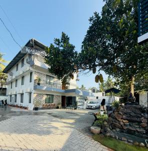a woman sitting in front of a building at Nakshatra in Kovalam