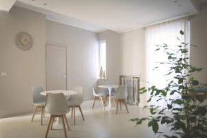 a white room with tables and chairs and a plant at B&B Il Rifugio Urbano in Pescara