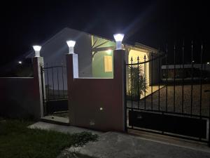 a house with a gate at night with lights at Rêve Bleu in Capesterre