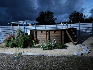 a wooden plunge pool in a garden with a fence at Rêve Bleu in Capesterre