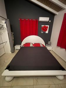 a bed in a room with a red curtain at Rêve Bleu in Capesterre