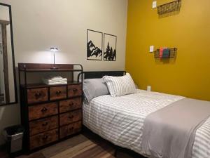 a bedroom with a bed and a dresser with a bed at Pintler's Portal Hostel in Anaconda