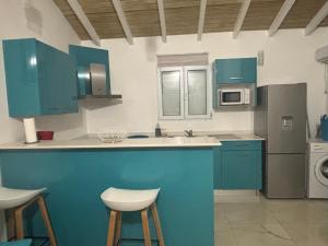 a kitchen with blue cabinets and white counter tops at Rêve Bleu in Capesterre