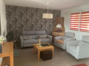 a living room with two couches and a table at Le Relais du 49 - Gîte in La Séguinière +17 photos