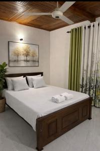 a bedroom with a large bed with two towels on it at Jasmine Breeze Villa in Kadawata