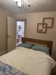a bedroom with a bed and a bathroom at Pine Tree Cottage in Linslade +2 photos