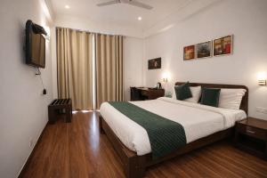 a hotel room with a bed and a television at EMBLEM Hotel - Arjun Marg, Golf Course Road, Gurgaon in Gurgaon