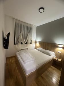 a bedroom with a large white bed and a window at Emerald Mamba - Titova Vila in Zlatibor