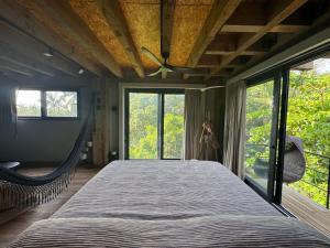 a large bed in a room with windows at KINEKI La Punta - Casa Karen in Brisas de Zicatela