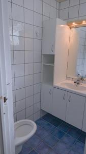 a white bathroom with a toilet and a sink at Svingen Apartments in Balestrand