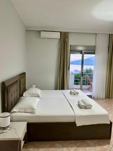 a bedroom with a large bed and a balcony at Hotel Amaiià in Sarandë