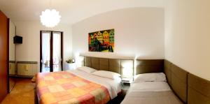 a bedroom with two beds and a painting on the wall at Oasi Brembate Bed and Breakfast in Brembate