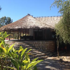 a house with a straw roof and stairs in front at Villa Ny Onja in Mahajanga