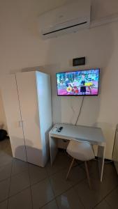 a desk with a chair and a tv on a wall at White House B&B in Melfi