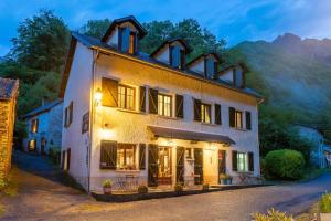 a large white building with lights on at Auberge Les Myrtilles in Couflens