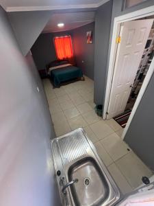 a bathroom with a sink and a room with a bed at Hostal JV Loft Simple in Nogales