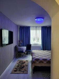a bedroom with a bed and a table and a tv at Studio Maria in Galaţi