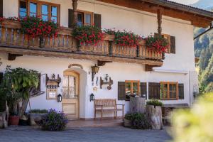 a building with a balcony with flowers on it at Mayringerlehen in Ramsau