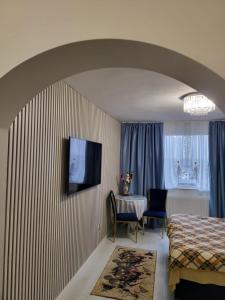 a hotel room with a bed and a table and a television at Studio Maria in Galaţi
