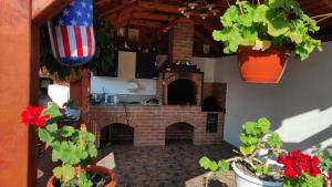 an outdoor kitchen with a brick fireplace and plants at Casa Foltea in Călimăneşti