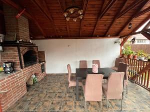 a patio with a table and chairs and a fireplace at Casa Foltea in Călimăneşti
