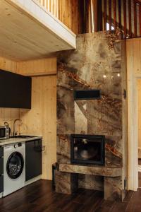 a kitchen with a stove and a stone wall at Veranda Rozhanka in Verkhnyaya Rozhanka