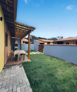 a backyard with a patio with a grass yard at Vila Tero 400 metros da praia de Boraceia in São Sebastião