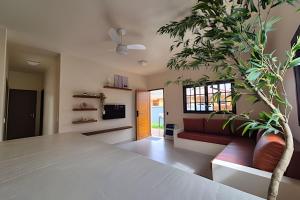 a living room with a table and a plant at Vila Tero 400 metros da praia de Boraceia in São Sebastião