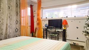 a bedroom with a bed and a desk and a window at Le LiloVert - Studio 24 m2 in Le Carbet