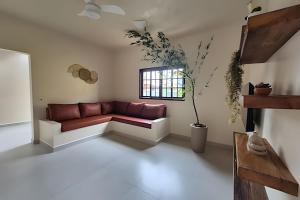 a living room with a red couch and a window at Vila Tero 400 metros da praia de Boraceia in São Sebastião