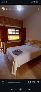a bedroom with a large white bed with a window at Pousada DrChico in Poço Fundo +43 photos