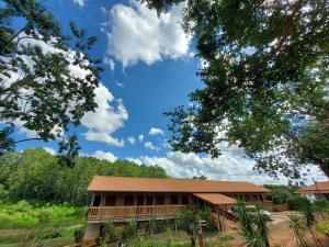 a building with a brown roof and some trees at Pousada DrChico in Poço Fundo