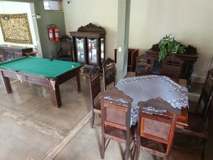 a room with a ping pong table and chairs at Pousada DrChico in Poço Fundo