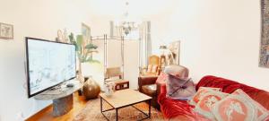 a living room with a couch and a tv at PARIS AUTHENTIC HOUSE Métro 7 Pierre et Marie Curie in Paris
